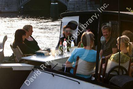People ride and dine on a canal boat on the Amstel River in Amsterdam, Netherlands.