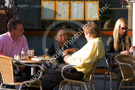 People dine and socialize at an outdoor cafe in Amsterdam, Netherlands.