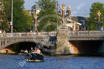 Boating cruising on the Amstel River in Amsterdam, Netherlands.