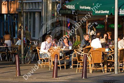 People dine and socialize at an outdoor cafe in Amsterdam, Netherlands.