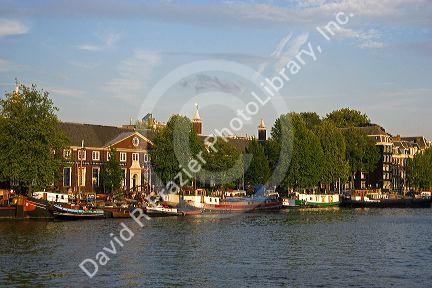 Boats docked along the Amstel River in Amsterdam, Netherlands.