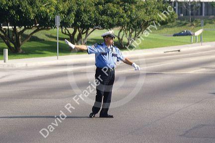 Male traffic officer blowing a whistle, directing traffic in Los Angeles, California.