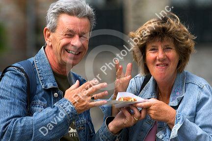 Tourists eat a Belgian waffle at Bruge in the province of West Flanders, Belgium.