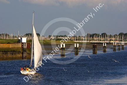 A sail boat at Nieuwpoort harbor entrance in the province of West Flanders, Belgium.