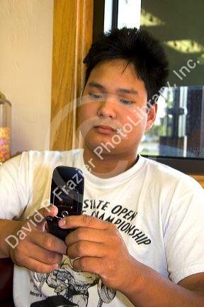 Asian man text messaging with his cell phone in Boise, Idaho.