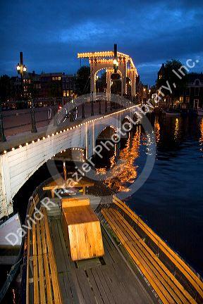 A bridge over the Amstel River at dusk in Amsterdam, Netherlands.
