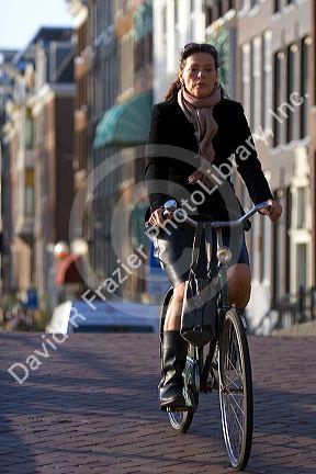 Woman riding a bicycle on the street in Amsterdam, Netherlands.