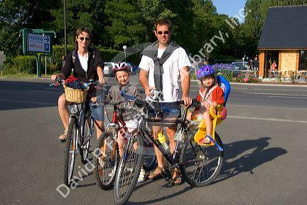 French family on bicycles near Le Mont Saint Michel in the region of Basse-Normandie, France.