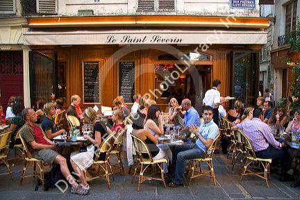 People dine at an outdoor cafe in Paris, France.