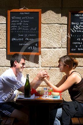 A young couple in love dine at a sidewalk cafe in Saint-Malo in Brittany, northwestern France.