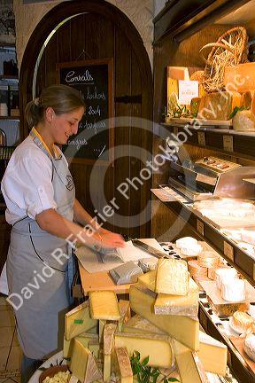 Woman working in a cheese shop in Paris, France.