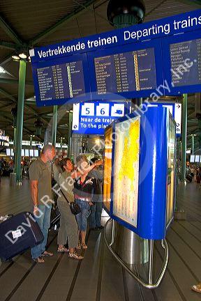 People buy tickets for the train in the terminal at the Schiphol Airport in Amsterdam, Netherlands.