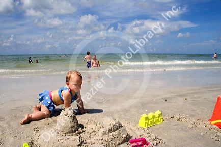 Infant child crawling on the beach at St. Petersburg, Florida. MR