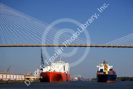 Container ships pass under the Talmadge Memorial Bridge on the Savannah River at the Port of Savannah in Savannah, Georgia.