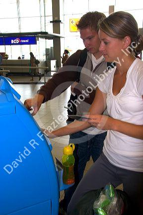 People buy tickets for the train in the terminal at Schiphol Airport in Amsterdam, Netherlands.