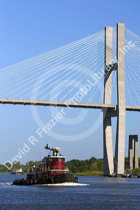 A tugboat passes under the Talmadge Memorial Bridge on the Savannah River at Savannah, Georgia.