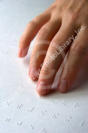 Hand reading braille.