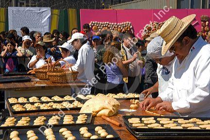 Bread being made into the shape of a skull to be given to a crowd of people celebrating the Day of the Dead in the Zocalo in Mexico City, Mexico.