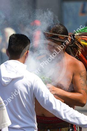 Aztec indian in traditional dress performing a spiritual ceremony with smoke on the Day of the Dead in Mexico City, Mexico.