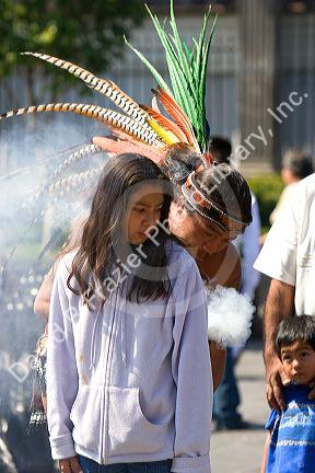 Aztec indian in traditional dress performing a spiritual ceremony with smoke on the Day of the Dead in Mexico City, Mexico.