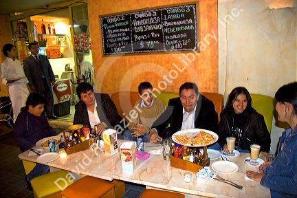 Mexican family eating pizza at a sidewalk cafe in Mexico City, Mexico.
