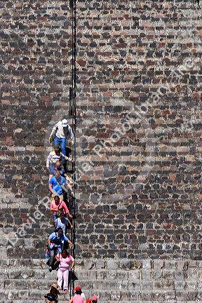 Tourists walk down steps using a railing on the Pyramid of the Moon at Teotihuacan in the State of Mexico, Mexico.