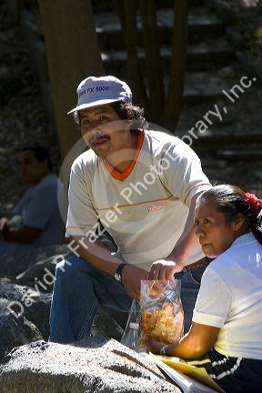 Mexican man and woman relax and have a snack in Chapultepec Park in Mexico City, Mexico.