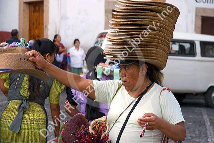 Mexican street vendor selling hats in the plaza at Taxco in the State of Guerrero, Mexico.