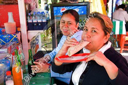 Mexican woman eating a quesadilla in Mexico City, Mexico.