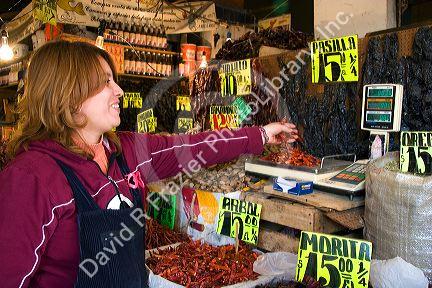 Vendor weighing dried chilis at the Merced Market in Mexico City, Mexico.