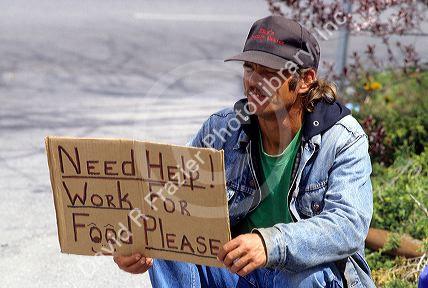Homeless man holding a sign.