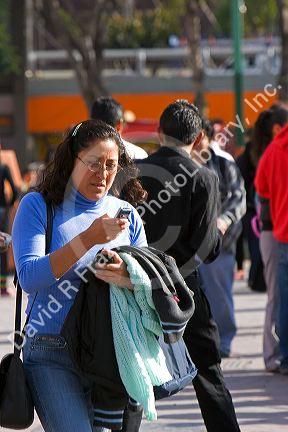 Mexican woman using a cell phone in Mexico City, Mexico.