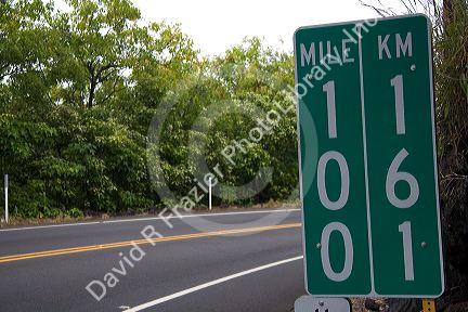 Roadside mile marker showing measurements in miles and kilometers on the Big Island of Hawaii.