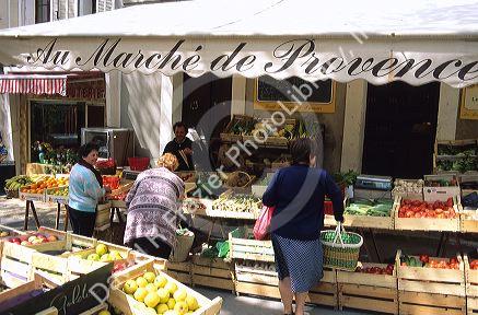 Women shop at an open air fruit and vegetable market in Paris, France.