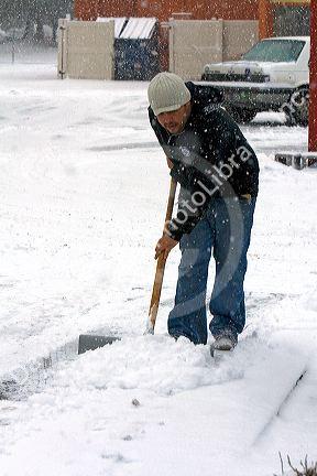 Man shoveling snow from sidewalks in Boise, Idaho.