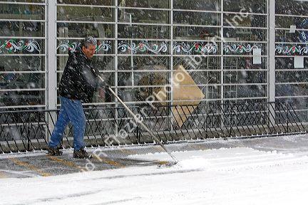 Man shoveling snow in front of a business in Boise, Idaho.