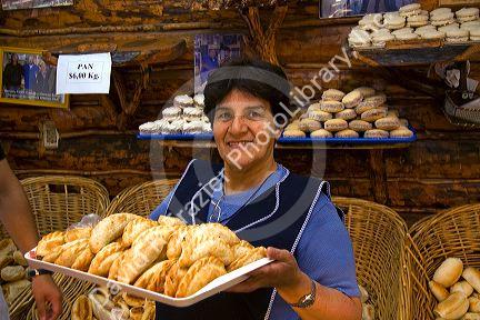 Woman holding a tray of empanadas in a bakery at Tolhuin in the province of Tierra del Fuego, Argentina.