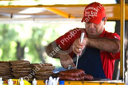 Food vendor grilling chorizo sausage along the Rio de la Plata in Buenos Aires, Argentina.