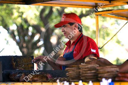 Food vendor grilling chorizo sausage along the Rio de la Plata in Buenos Aires, Argentina.