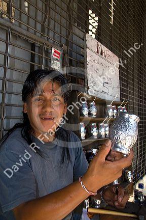 Street vendor selling silver mate cups in Buenos Aires, Argentina.
