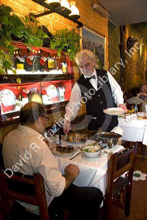 Waiter serving a customer at a restaurant in Buenos Aires, Argentina.