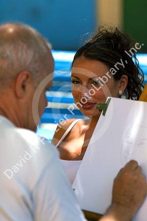 Woman having her portrait drawn by a street artist in the La Boca barrio of Buenos Aires, Argentina.