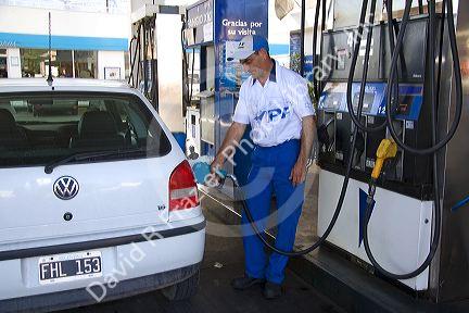 YFP gas station attendent fueling up a car in Mendoza, Argentina.