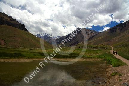 People walk on a trail in the Andes Mountain Range near the Chile border in Argentina.