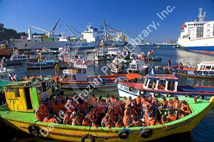 Passengers on a boat tour wearing life jackets in the Port at Valparaiso, Chile.