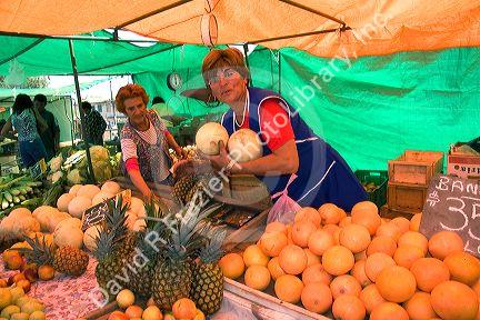 Woman selling produce at an outdoor market in Valparaiso, Chile.