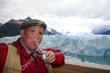 American man drinking mate at the Perito Moreno Glacier in Patagonia, Argentina.