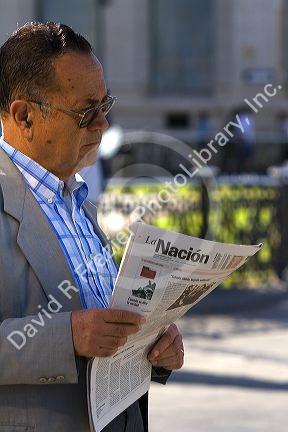 Man reading a spanish language newspaper La Nacion in Valparaiso, Chile.