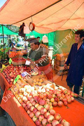 Vendor selling fruit at an outdoor produce market in Valparaiso, Chile.