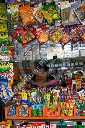 Young girl working in a kiosk selling snacks and magazines in Santiago, Chile.